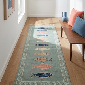Handmade nautical runner rug with multicolor fish pattern on green background for beach house interiors