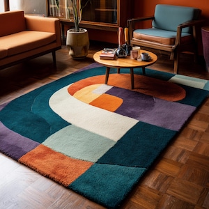 May include: A rectangular rug with an abstract design in shades of teal, orange, purple, and white. The rug's design incorporates geometric shapes and curved lines, offering a contemporary look. The rug is suitable for a living room.