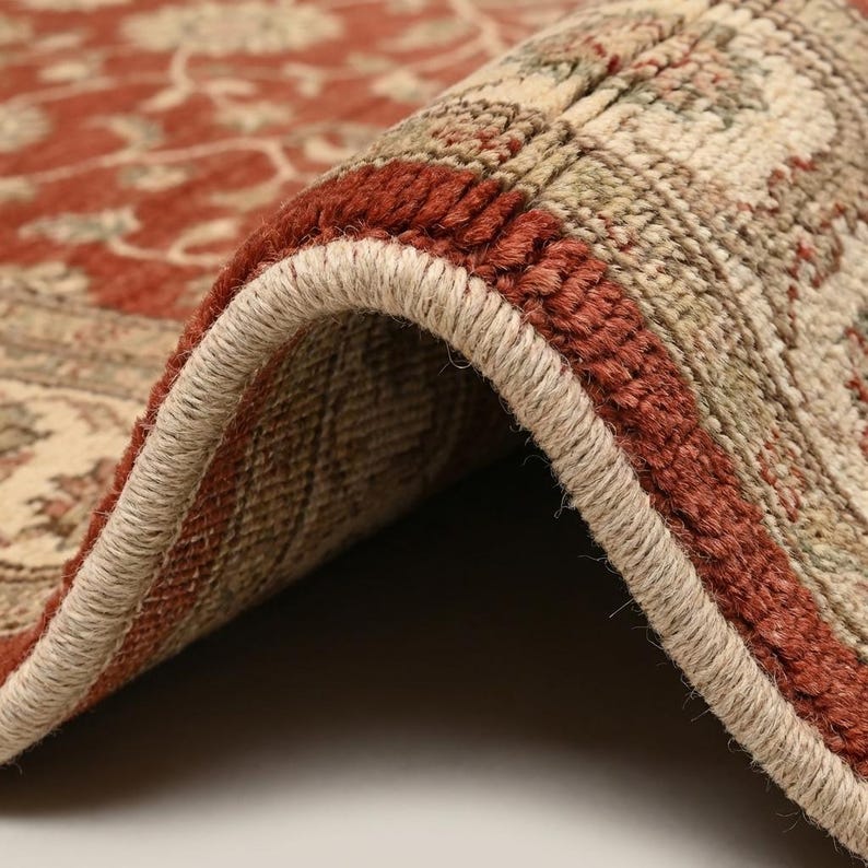 Close-up of hand knotted wool rug showing dense knot structure, soft wool fibers, and detailed floral weaving texture