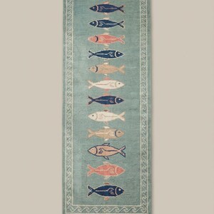Coastal wool runner rug with fish design placed in bright kitchen space with white flooring and natural light