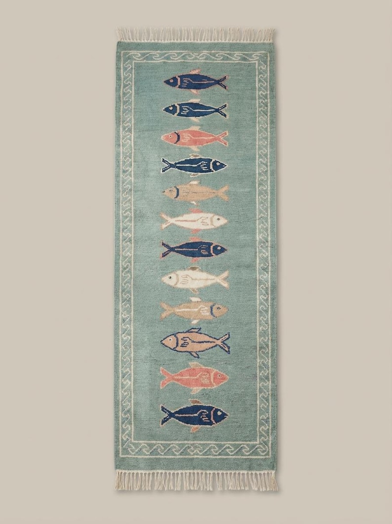 Coastal wool runner rug with fish design placed in bright kitchen space with white flooring and natural light