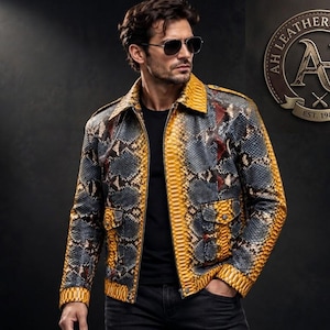 May include: A jacket featuring a snakeskin pattern in shades of yellow, gray, and black, with a collar, front zipper, and two flap pockets. The logo AH LEATHERS CRAFTS EST. 1985 is visible in the upper right corner of the image.
