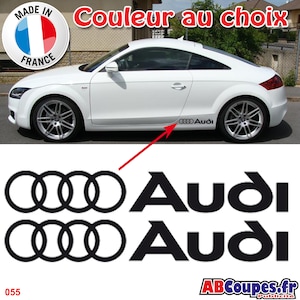 Peut inclure: Une voiture Audi blanche avec des autocollants de logo Audi noirs. L'image comprend un autocollant "Made in France" et le texte "Couleur au choix". Les autocollants présentent les anneaux Audi et le mot-symbole Audi. L'image comprend également l'adresse du site Web "ABCoupes.fr".