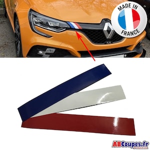 Peut inclure: Une voiture orange avec une calandre et des phares noirs. La voiture a un autocollant rayé bleu, blanc et rouge. Trois autocollants séparés en bleu, blanc et rouge sont affichés en dessous. Un autocollant indique "Made in France".