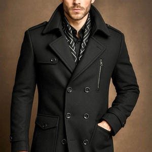 May include: A black double-breasted coat featuring a wide collar, epaulets, and a vertical zippered chest pocket. The coat includes two lower flap pockets, buttoned cuffs, and a black shirt underneath with a white geometric patterned scarf.