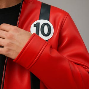 May include: A vibrant red jacket with a black stripe down the sleeve and a white circular patch featuring the number "10". The jacket has a stand-up collar and a zipper closure. The design is reminiscent of a racing or superhero style.