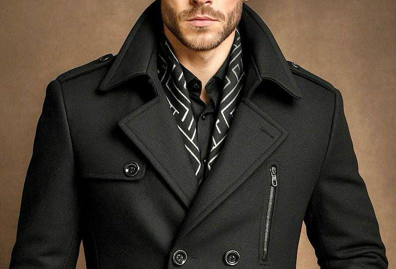 May include: A black double-breasted coat featuring a wide notched lapel, shoulder epaulets, and a vertical zippered pocket on the chest. The coat is worn over a black button-down shirt and a black scarf with a white geometric line pattern.
