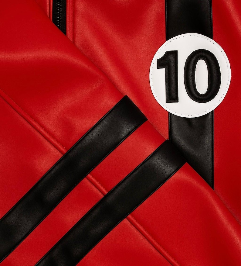May include: Close-up of a red jacket with black stripes and a white circle with the number 10 in black. The jacket has a zipper and is made of a smooth material.