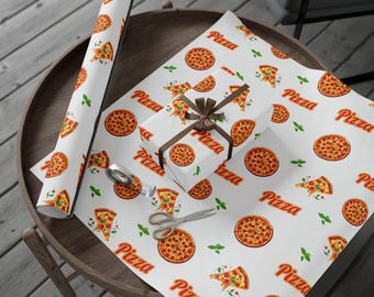 May include: White wrapping paper with a pizza design, showing whole pizzas, pizza slices, and the word "Pizza" in orange. A wrapped gift with a brown ribbon and scissors are on the paper. A roll of the same paper is on the left.