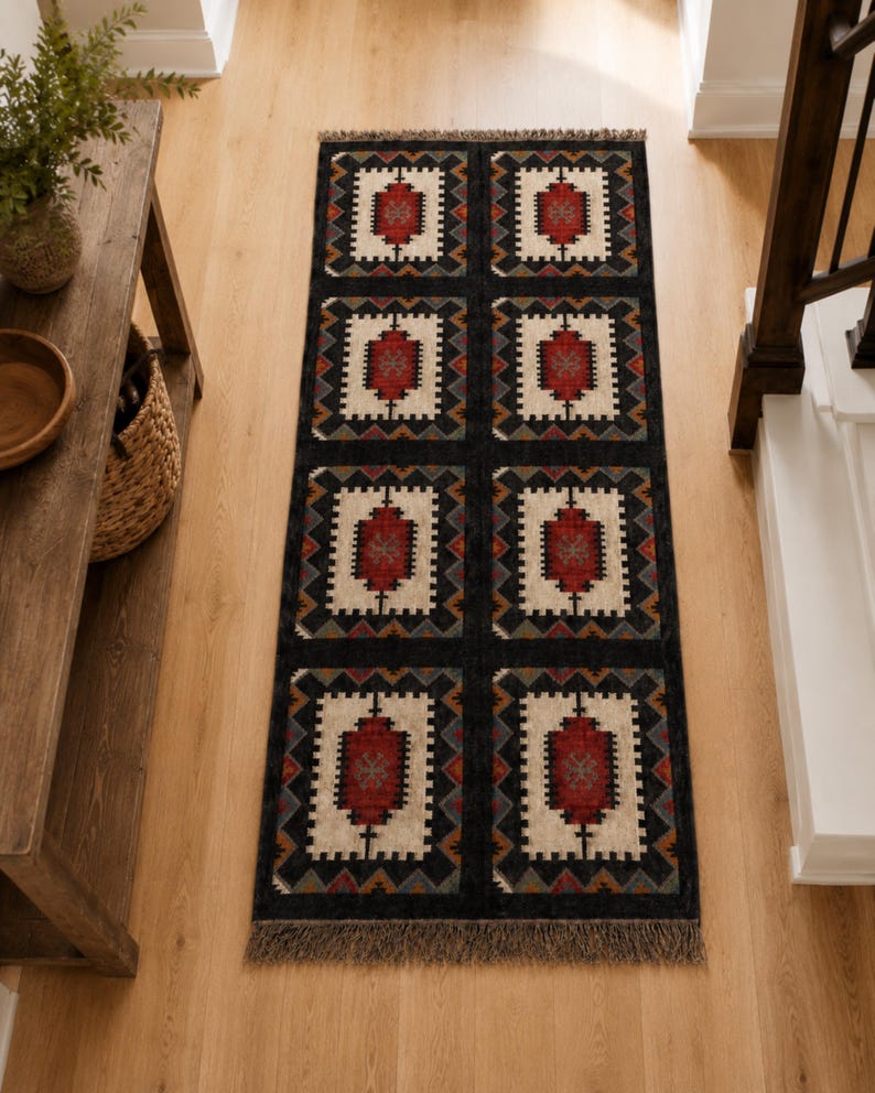 Top view of dark charcoal tribal area rug with repeating square medallion motifs in multicolor, handmade flatweave wool jute rug with fringe