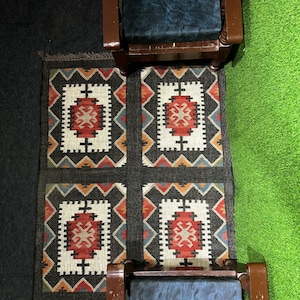 Rustic black tribal flatweave rug handwoven by artisans in Jaipur India, bold southwestern geometric medallion pattern in rust red ivory and teal