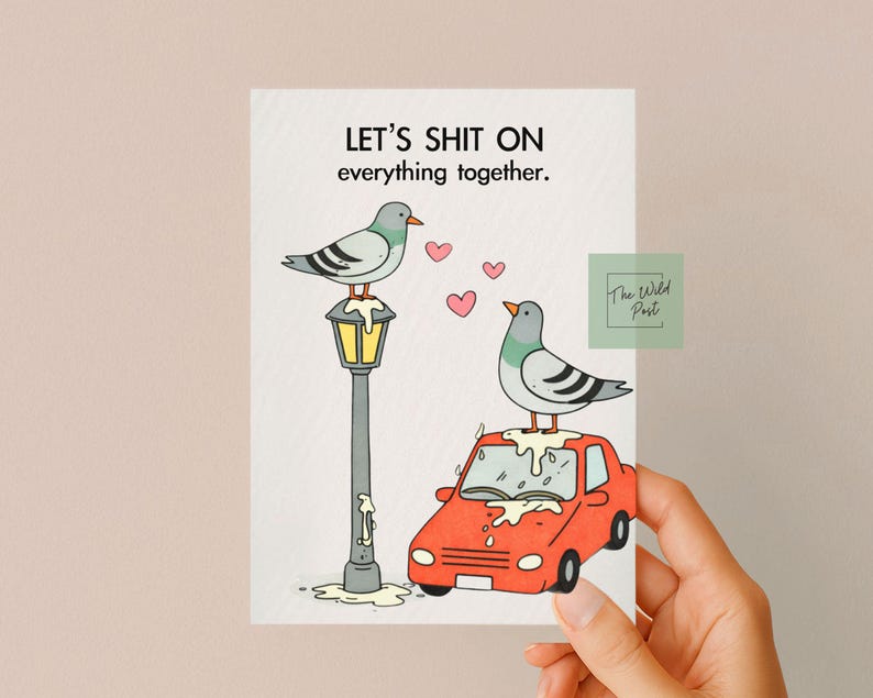 Pode incluir: Um cart&atilde;o de felicita&ccedil;&otilde;es humor&iacute;stico com o texto "LET'S SHIT ON everything together." apresenta dois pombos de desenho animado, um numa l&acirc;mpada e outro num carro vermelho. Cora&ccedil;&otilde;es cor-de-rosa flutuam no ar. O log&oacute;tipo The Wild Post est&aacute; no canto.
