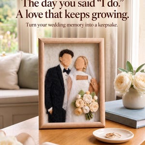 Può includere: Un ritratto in feltro ad ago di una coppia di sposi in una cornice di legno chiaro. Il testo recita: A PERSONALISED ANNIVERSARY GIFT. The day you said “I do.” A love that keeps growing. Turn your wedding memory into a keepsake.