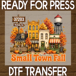 May include: A DTF transfer sheet featuring a fall-themed small town scene with buildings, a water tower, and autumn trees. Text includes 'READY FOR PRESS', '37203 Nashville, TN', 'Small Town Fall', and 'DTF TRANSFER' with pumpkins and coffee signage.