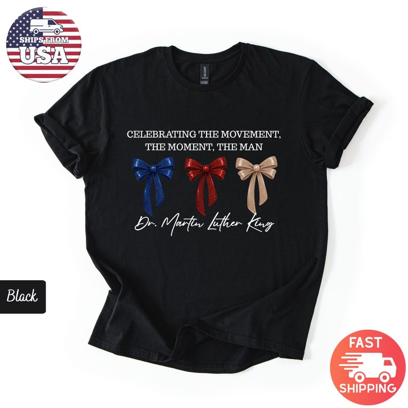 Peut inclure: T-shirt noir avec l'inscription "CELEBRATING THE MOVEMENT, THE MOMENT, THE MAN" et "Dr. Martin Luther King". Le motif comprend trois n&oelig;uds papillon bleus, rouges et beiges. Le t-shirt a un col rond classique.