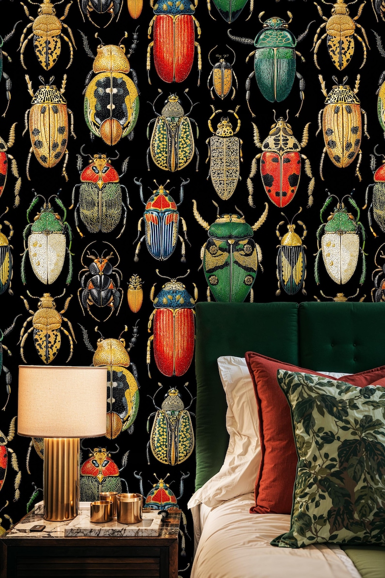 Beetle wallpaper in a stylish bedroom with green velvet headboard, rust and botanical pillows, and warm bedside lighting. The vintage entomology mural adds depth and artistic character to the room.