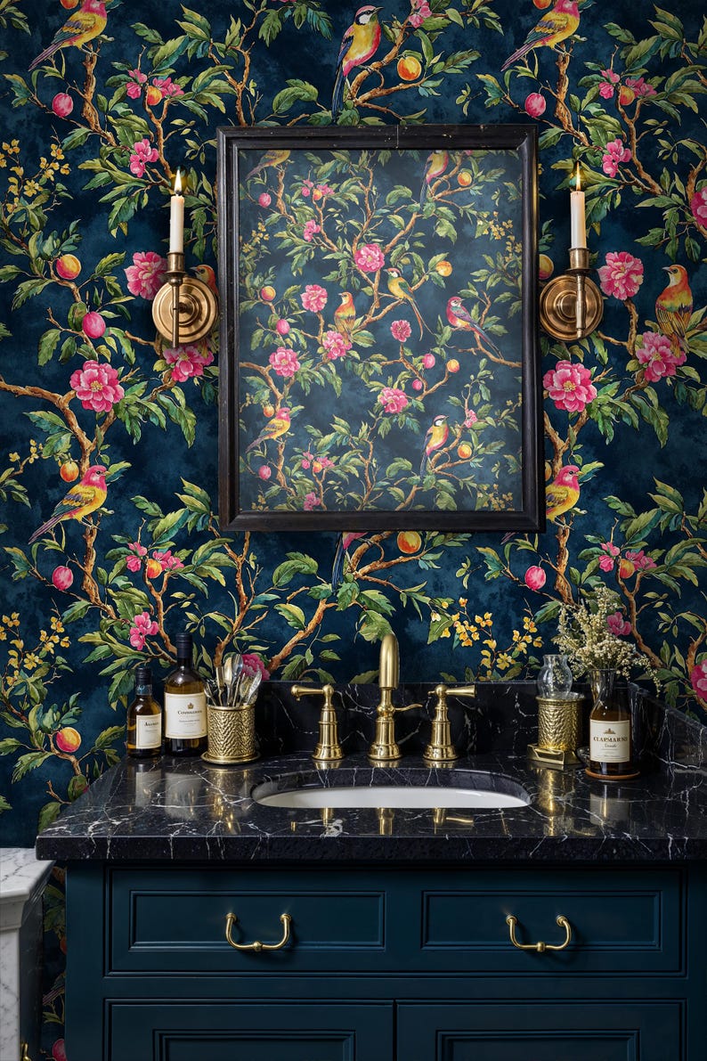Luxurious bathroom featuring a navy chinoiserie floral wallpaper with detailed birds and blossoms. The mural is paired with a black marble vanity, gold faucets, and wall sconces, creating a dramatic statement wall with timeless botanical elegance.