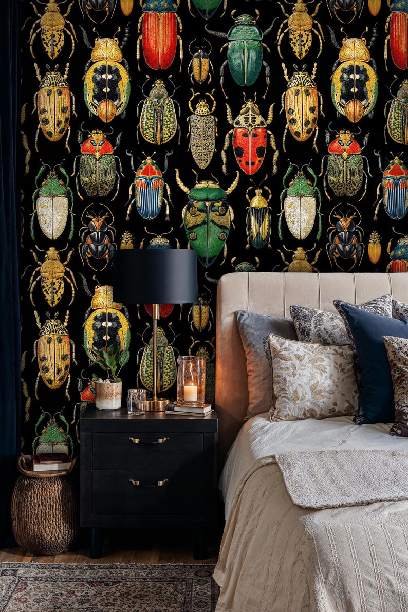 Colorful beetle wallpaper in a cozy bedroom with dark wooden nightstand, brass lamp, and soft beige bedding. The detailed insect illustration wall mural adds an elegant entomology-inspired touch to the interior decor.
