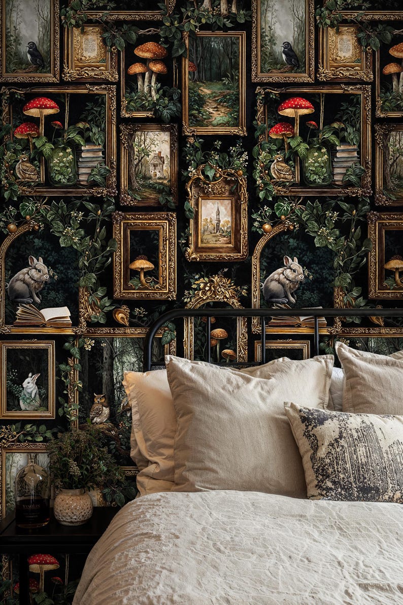 Dark academia gallery wallpaper featuring vintage gold frames, forest illustrations, mushrooms, and rabbits behind a cozy neutral bed with layered pillows, creating a moody gothic cottagecore bedroom atmosphere.