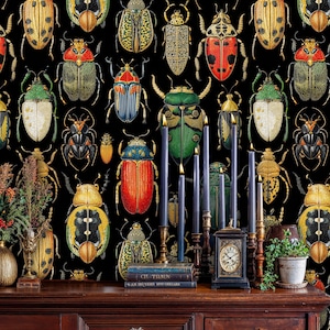 Artistic beetle illustration wall mural featuring colorful insects on black background, styled with antique wooden console, candles, and vintage books for a classic natural history interior.