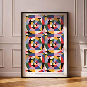 Könnte beinhalten: Ein gerahmter Kunstdruck mit einem geometrischen Muster aus konzentrischen Kreisen und farbigen Formen. Das Kunstwerk enthält rote, grüne, blaue, gelbe und schwarze Elemente. Der Name des Künstlers, "Fernando Botero", ist unten auf dem Druck zu sehen.