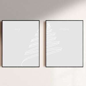 May include: Two framed minimalist art prints. Each print features a light gray background with a white line drawing of a Christmas tree. The word "merry" is above the tree on the left print, and "christmas" is above the tree on the right print.