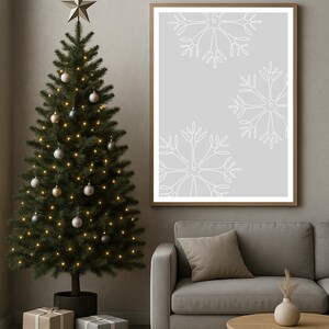 Könnte beinhalten: Ein weihnachtliches Interieur mit einem geschmückten Weihnachtsbaum, einem gerahmten Druck mit weißen Schneeflocken-Designs und verpackten Geschenken. Die Szene umfasst ein graues Sofa, einen Holztisch und einen neutralen Teppich.