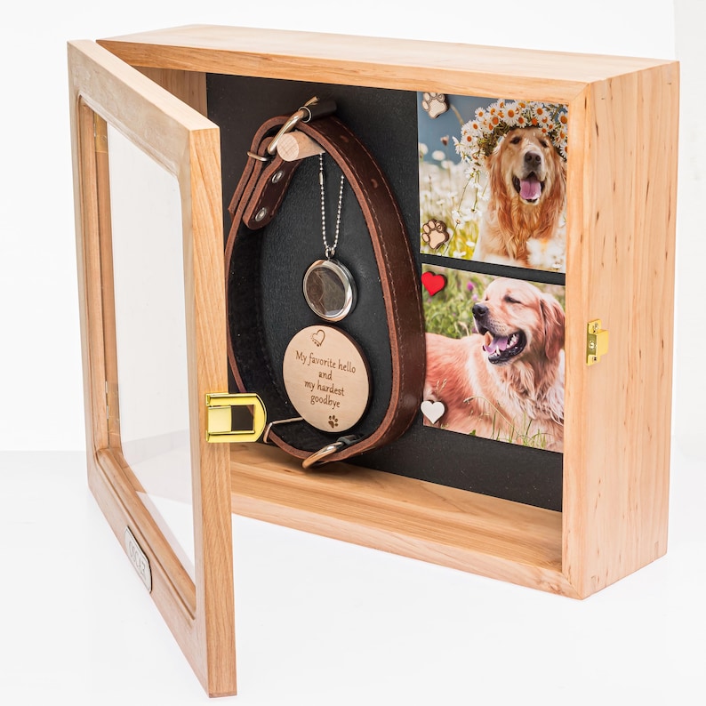 Pu&ograve; includere: Una scatola commemorativa in legno per animali domestici con porta in vetro, che mostra un collare per cani in pelle marrone, un ciondolo e due foto di un golden retriever. Il ciondolo recita "My favorite hello and my hardest goodbye."