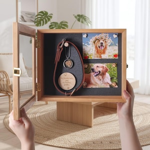 Pu&ograve; includere: Una scatola commemorativa in legno per animali domestici con porta in vetro, che mostra un collare in pelle, un ciondolo e due foto di un golden retriever. La scatola include il testo "My favorite hello and my hardest goodbye."
