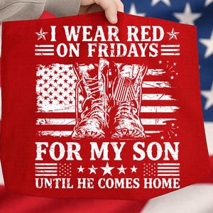 May include: Red tote bag with white text: "I WEAR RED ON FRIDAYS FOR MY SON UNTIL HE COMES HOME." The design includes an American flag and a pair of boots. The bag is held up by a person.