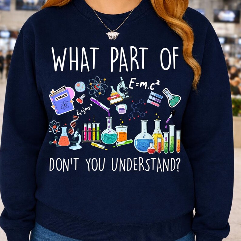 Może przedstawiać: Granatowa bluza z napisem "WHAT PART OF DON'T YOU UNDERSTAND?" oraz grafiką o tematyce naukowej. Grafika zawiera zlewki, prob&oacute;wki i wzory naukowe, takie jak E=mc&sup2;.