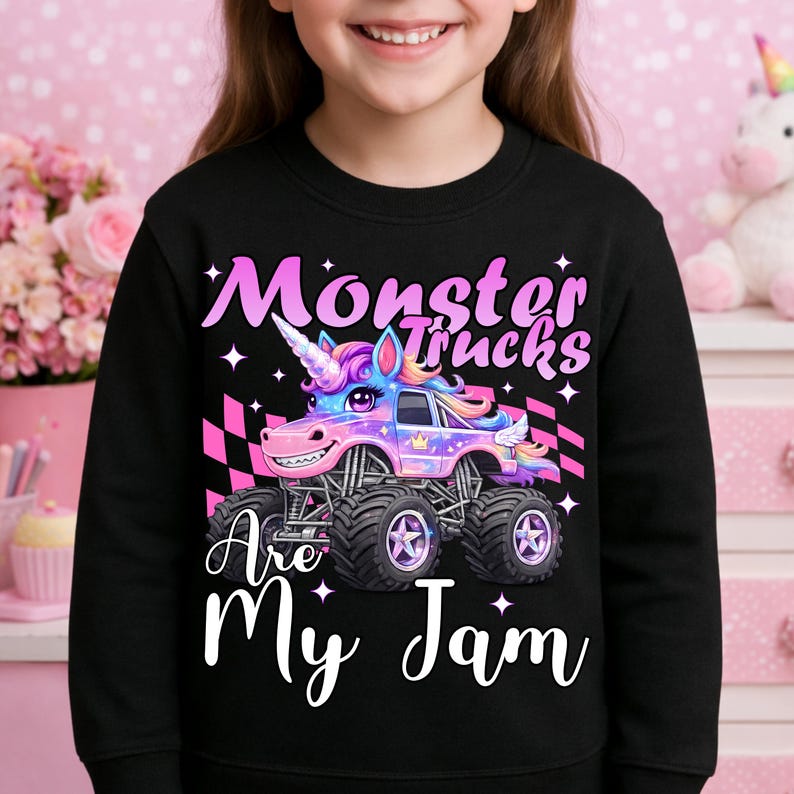 Puede incluir: Sudadera negra con un gr&aacute;fico colorido de un cami&oacute;n monstruo unicornio y el texto "Monster Trucks Are My Jam". El cami&oacute;n tiene un cuerno, alas y una cara sonriente. El dise&ntilde;o incluye detalles a cuadros rosas y blancos.