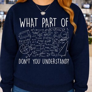 Peut inclure: Sweat-shirt bleu marine avec texte blanc et &eacute;quations math&eacute;matiques. Le texte dit "WHAT PART OF DON'T YOU UNDERSTAND ?" Diverses formes g&eacute;om&eacute;triques et formules sont affich&eacute;es autour du texte.