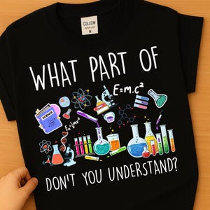 Może przedstawiać: Czarna koszulka z grafiką o tematyce naukowej. Projekt zawiera sprzęt laboratoryjny, atomy oraz tekst "WHAT PART OF DON'T YOU UNDERSTAND?" i "E=mc&sup2;". Widoczna jest mała metka z napisem "COLLOW".