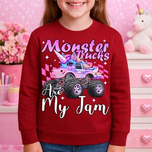 Puede incluir: Una sudadera burdeos con un gr&aacute;fico colorido de un cami&oacute;n monstruo dise&ntilde;ado como un unicornio. El texto "Monster Trucks Are My Jam" se muestra en escritura blanca. El dise&ntilde;o incluye un patr&oacute;n de bandera a cuadros y estrellas.