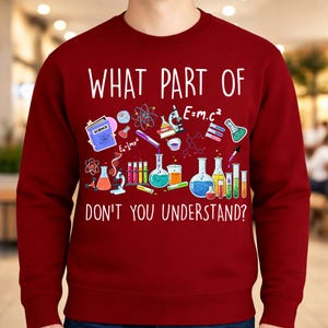 Może przedstawiać: Bordowa bluza z napisem "WHAT PART OF DON'T YOU UNDERSTAND?" w kolorze białym. Projekt zawiera kolorowe ilustracje element&oacute;w związanych z nauką, takich jak zlewki, prob&oacute;wki i symbole naukowe.