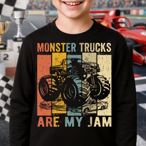 Puede incluir: Sudadera negra con un gr&aacute;fico de monster truck y el texto "MONSTER TRUCKS ARE MY JAM" en un estilo retro. El dise&ntilde;o presenta un monster truck con una parrilla en forma de calavera y otros veh&iacute;culos.