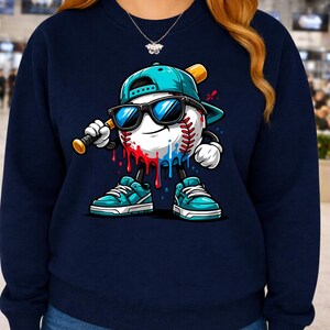 May include: Navy blue sweatshirt featuring a baseball character with sunglasses, a baseball bat, and a baseball cap. The baseball has red and blue paint drips. The character is wearing teal sneakers with white laces.