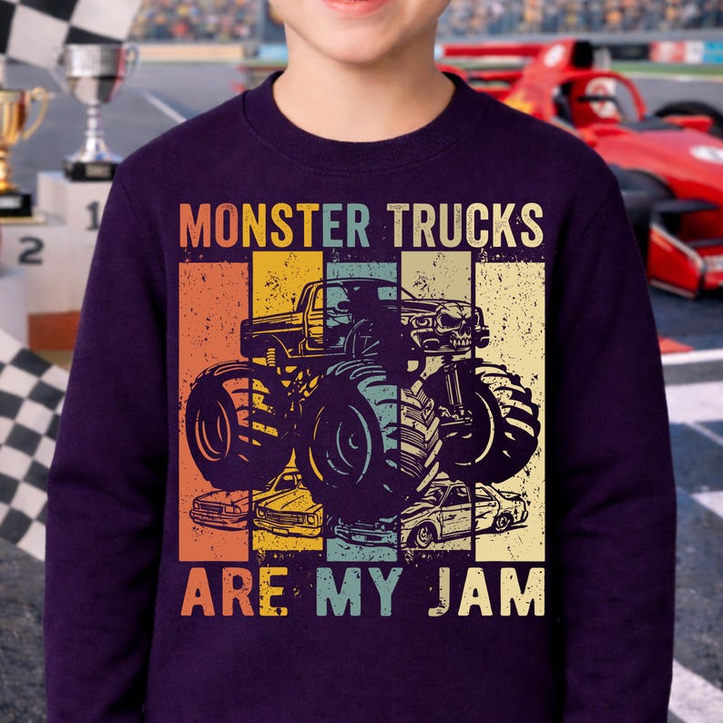 Puede incluir: Sudadera morada oscura con un gr&aacute;fico de monster truck y el texto "MONSTER TRUCKS ARE MY JAM". El dise&ntilde;o tiene un aspecto vintage y desgastado, con un fondo de bloques de color en naranja, amarillo, azul y verde.