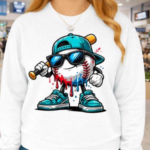 May include: White sweatshirt featuring a cartoon baseball character wearing sunglasses, a teal baseball cap, and teal sneakers. The baseball has red and blue paint dripping down. The character is holding a baseball bat.