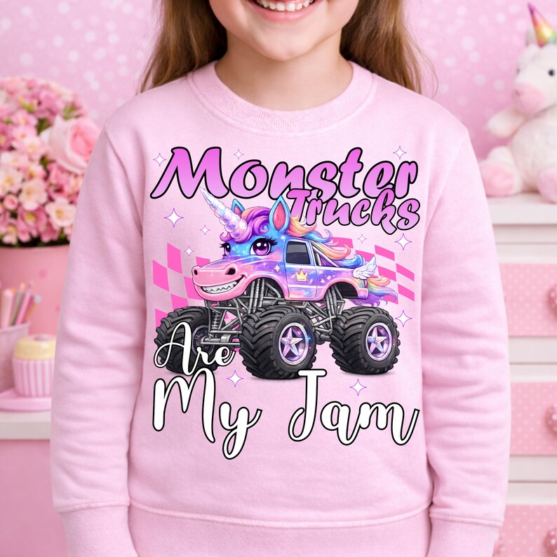 Puede incluir: Sudadera rosa con un cami&oacute;n monstruo colorido con un cuerno de unicornio y el texto "Monster Trucks Are My Jam". El dise&ntilde;o incluye una bandera a cuadros y estrellas. La sudadera es de color rosa liso.