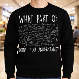 Peut inclure: Sweat-shirt noir avec texte blanc et &eacute;quations math&eacute;matiques. Le texte dit "WHAT PART OF DON'T YOU UNDERSTAND?" avec diverses formules et formes g&eacute;om&eacute;triques, dont une sph&egrave;re, un triangle et un rectangle.