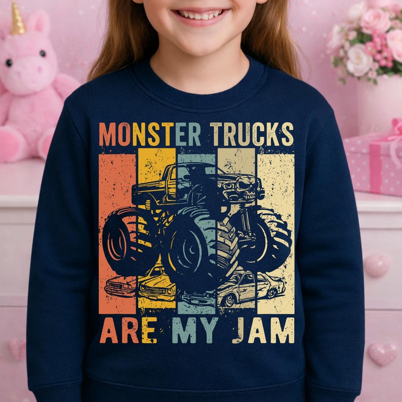 Puede incluir: Sudadera azul marino con un dise&ntilde;o de monster truck. El dise&ntilde;o incluye una imagen de monster truck y el texto "MONSTER TRUCKS ARE MY JAM" en un estilo retro, con un fondo de bloques de color.