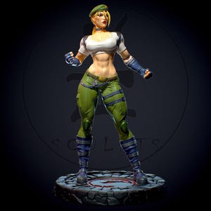 May include: A detailed figurine of a female character in a fighting stance. She wears a white and black top, green trousers, and blue boots. Her blonde hair is pulled back under a green beret. The figure stands on a stone base.