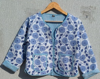 May include: A blue and white floral print jacket with two front pockets and a striped lining. The jacket is hanging on a wooden hanger. The floral pattern features blue flowers and leaves on a white background.