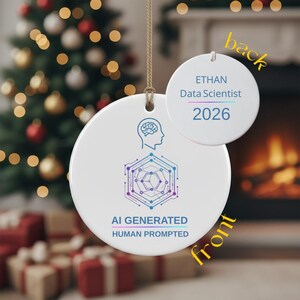 May include: A round white ceramic ornament featuring a blue and purple graphic of a human head with a brain and a geometric network. The text reads AI GENERATED HUMAN PROMPTED. The back displays ETHAN Data Scientist 2026 in blue and purple text.