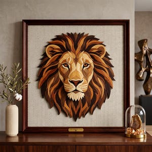 May include: A framed wooden lion head sculpture. The artwork features a detailed mosaic of various wood tones, creating a realistic depiction of a lion's face and mane. The frame is dark brown, and the background is a light beige fabric.