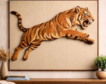 Könnte beinhalten: Holzskulptur eines springenden Tigers mit detaillierten Holzmaserungsmustern in Braun- und Schwarztönen. Das Kunstwerk ist auf einer beigefarbenen Leinwand in einem dunkelbraunen Rahmen montiert. Das offene Maul und die ausgestreckten Pfoten des Tigers vermitteln Bewegung.