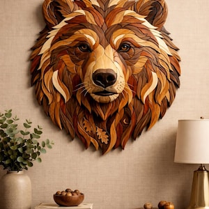 May include: A wooden bear head sculpture, mounted on a wall. The artwork uses various wood tones, from light beige to dark brown, creating a textured, layered effect. The bear's face is intricately carved, showcasing its eyes, nose, and fur. A decorative wall hanging.