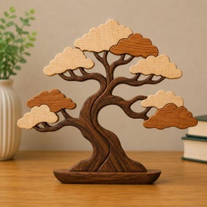 May include: A decorative wooden sculpture shaped like a bonsai tree, featuring a dark brown trunk and base with contrasting light tan and medium brown cloud-shaped foliage pieces attached to the branches, creating a layered, multi-toned appearance.